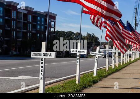 DULUTH, USA - 07. Nov 2020: Duluth, Georgia / USA - 6. November 2020: Weiße Kreuze und amerikanische Flaggen säumen eine Stadtstraße in Erinnerung Stockfoto