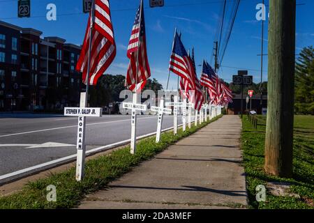 DULUTH, USA - 07. Nov 2020: Duluth, Georgia / USA - 6. November 2020: Weiße Kreuze und amerikanische Flaggen säumen eine Stadtstraße in Erinnerung Stockfoto