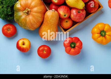 Kürbisse, Äpfel und Paprika Komposition auf blauem Hintergrund Stockfoto