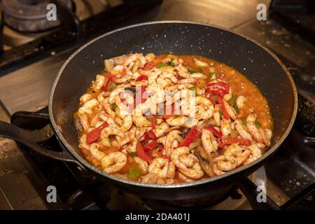 Garen Garnelen mit Austern mit Gemüse Tomaten und Grün und Mit Omelett auf einer Bratpfanne - auf einem Herd Mit Feuerhintergrund Stockfoto