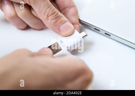 Der Mensch nutzt moderne Technologien, um Speicher und digitale Daten zu speichern. Typ-c Stockfoto