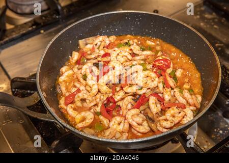 Garen Garnelen mit Austern mit Gemüse Tomaten und Grün und Mit Omelett auf einer Bratpfanne - auf einem Herd Mit Feuerhintergrund Stockfoto