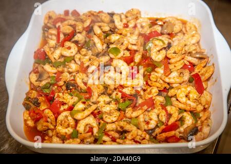 Garen Garnelen mit Austern mit Gemüse Tomaten und Grün und Mit Omelett auf einer Bratpfanne - auf einem Herd Mit Feuerhintergrund Stockfoto