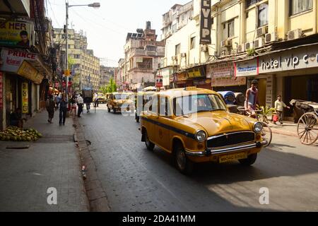 Kolkata, Indien - März, 2014: Oldtimer-Klassiker Ambassador-Taxi auf der Straße im historischen Viertel von Kalkutta. Gelbe Fahrstraße mit Fahrerhaus. Stockfoto