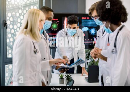 Multirassische Ärzte tragen Schutzmasken, Untersuchung Patienten CT-Scan der Brust und Bauchhöhle. Pulmonologie, Lungenpathologie, entzündlich Stockfoto