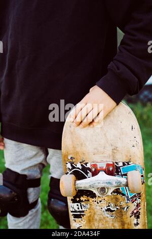 Nahaufnahme eines Skater Jungen mit einem alten Skateboard Vor einem  Graffiti-Wandbild Stockfotografie - Alamy
