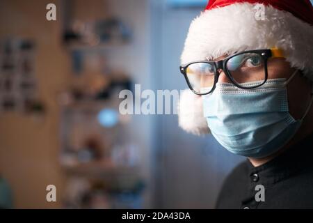 Weihnachtskonzept, kaukasischer Mann trägt medizinische Maske und santa Hut Stockfoto
