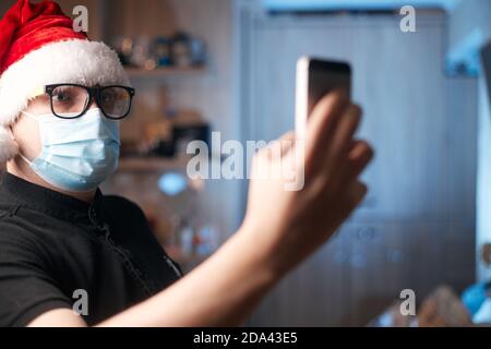 Weihnachtskonzept, kaukasischer Mann trägt medizinische Maske und santa Hut Stockfoto