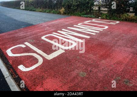 Langsames Schild auf der Straße Stockfoto