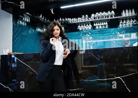 Wunderschöne indische Frau tragen formelle Posen im Café in der Nähe der Theke. Stockfoto