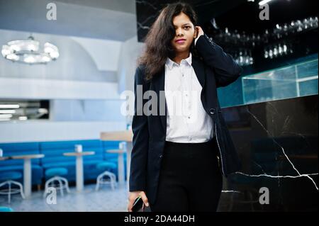 Wunderschöne indische Frau tragen formelle Posen im Café in der Nähe der Theke. Stockfoto