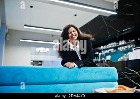 Wunderschöne indische Frau tragen formelle posiert im Café. Stockfoto