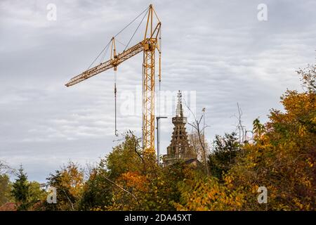 Gelber Baukran neben dem Turm der Burg kirche in Meisenheim Stockfoto