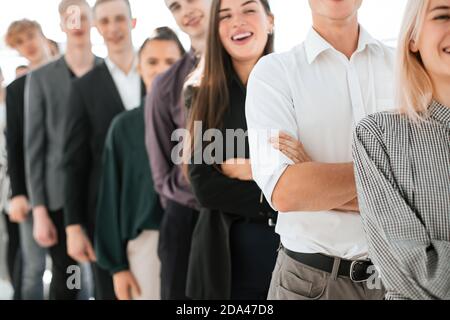 Junge Frau, die in einer Linie unter verschiedenen jungen Menschen steht Stockfoto