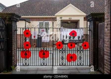 Datchet, Berkshire, Großbritannien. November 2020. Mohnblumen am Tor zum Fraueninstitut in Datchet. Dorfbewohner in Datchet haben Mohnblumen um das Dorfgrün gelegt, als sie an diesem Wochenende dem Kriegstoten des Dorfes in einem sozial distanzierten Gedenkgottesdienst für den Gedenktag Respekt zollen. Quelle: Maureen McLean/Alamy Stockfoto