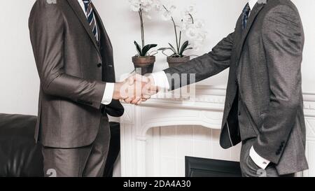 Ernsthafte junge Unternehmer die Hände schütteln. Konzept der Zusammenarbeit Stockfoto