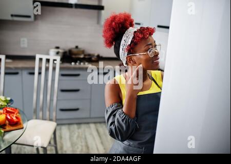 afroamerikanische Frau zu Hause Küche offenen Kühlschrank. Stockfoto
