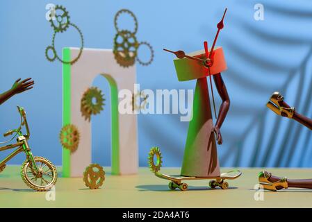 Zusammensetzung von Zahnrädern, Figuren, Bögen, Beine und Hände, Fahrrad und Skateboard, Konzept über Zeitmangel, Frist. Stockfoto