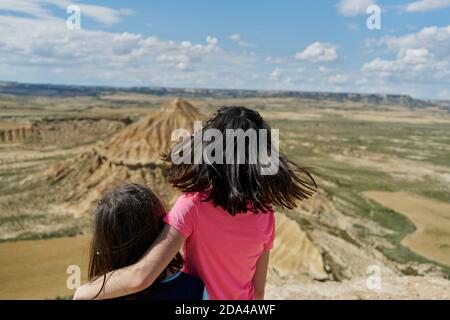 Kleine Schwestern im Blickpunkt beobachten einen Wüstenberg im Nationalpark Bardenas Reales in Navarra, Spanien. Reisekonzept Stockfoto