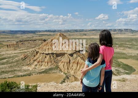 Kleine Schwestern im Blickpunkt beobachten einen Wüstenberg im Nationalpark Bardenas Reales in Navarra, Spanien. Reisekonzept Stockfoto