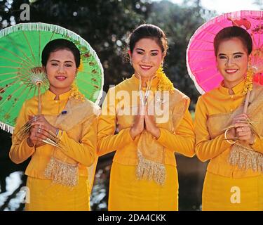 Thailand. Nakhon Pathom. Rosengarten. Drei junge Frauen, traditionelle Fingertänzerinnen, die im Garten posieren. Stockfoto