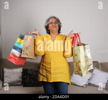Schöne indische Frau mit Einkaufstaschen und lächelnd. Stockfoto