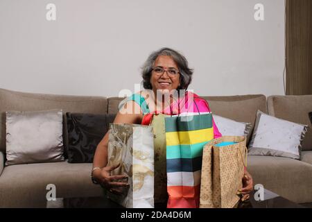 Schöne indische Frau mit Einkaufstaschen und lächelnd. Stockfoto
