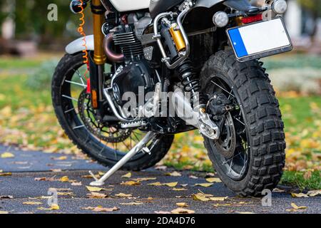 Sportmotorrad auf dem Bürgersteig im Park mit gelben Herbstblättern im Hintergrund geparkt, selektiver Fokus Stockfoto