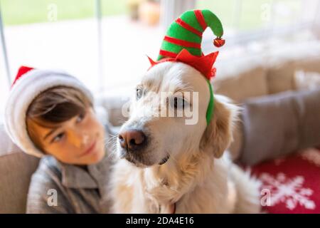 Junge und sein Hund genießen Weihnachten zusammen zu Hause Stockfoto