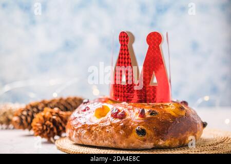 Rosca de reyes, spanischer Dreikönigskuchen, der an einem epiphany Tag auf einem grauen rustikalen Tisch gegessen wird Stockfoto