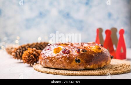 Rosca de reyes, spanischer Dreikönigskuchen, der an einem epiphany Tag auf einem grauen rustikalen Tisch gegessen wird Stockfoto