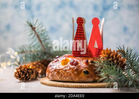 Rosca de reyes, spanischer Dreikönigskuchen, der an einem epiphany Tag auf einem grauen rustikalen Tisch gegessen wird Stockfoto