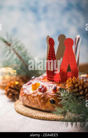 Rosca de reyes, spanischer Dreikönigskuchen, der an einem epiphany Tag auf einem grauen rustikalen Tisch gegessen wird Stockfoto