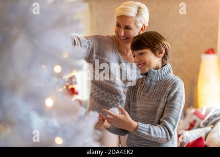 Mutter und Sohn schmücken Weihnachtsbaum Stockfoto