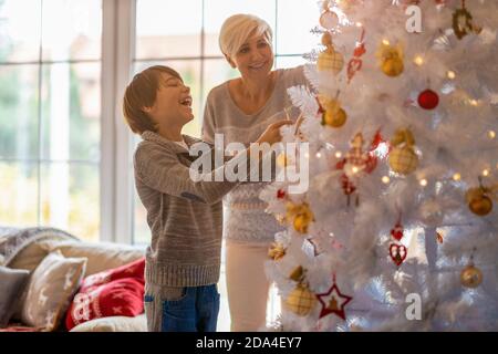 Mutter und Sohn schmücken Weihnachtsbaum Stockfoto