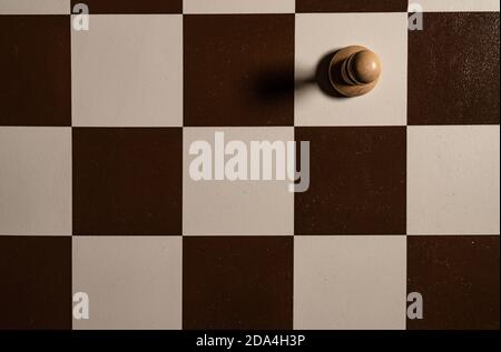 Spielen Holzschach auf einer Plattform in einem braunen Schachbrett, Figuren sind schwarz und Saatkrähen, Königinnen und Könige, Pferde Tisch im Dunkeln, stilvoll für Stockfoto