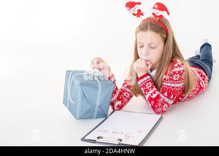 Liebe santa Brief von einem Kind zu Weihnachten geschrieben.Konzentriertes Kind ist in den Prozess des Denkens über alle ihre Wünsche und Wünsche beteiligt. Schön Stockfoto