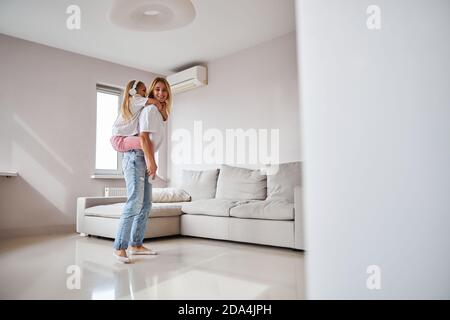 Junge schöne Mutter mit Spaß mit charmanten Tochter im Haus Am Wochenende Stockfoto