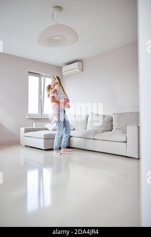 Nanny Spaß mit kleinen Mädchen in zu Hause beim Hören Musik im weißen Zimmer Stockfoto