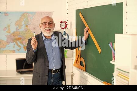 Versuchen Sie dies. Welcher Winkel Sie suchen. Geometrische Formen. High School moderne Bildung. Senior Mann Lehrer verwenden Lineal beim Zeichnen. Tutor Mann in Brille zeichnen mit Lineal auf Tafel. Zurück zur Schule. Stockfoto