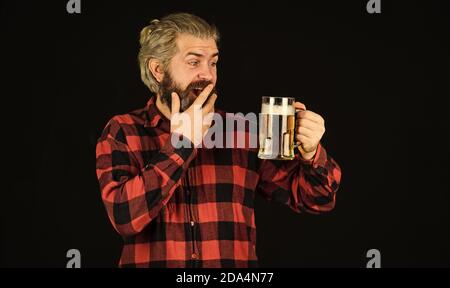 Überrascht männlichen Brauer. Brutal Hipster trinken Bier. Reife bärtige Mann halten Bierglas. Becher mit Alkohol Getränk. Selbstbewusster Barkeeper. Barkeeper in der Bar. Ruhe in der Kneipe. Prost. Sportbar. Probieren Sie ein neues Bier. Stockfoto