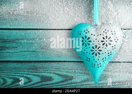 Herz und Schnee vor Holzhintergrund Stockfoto