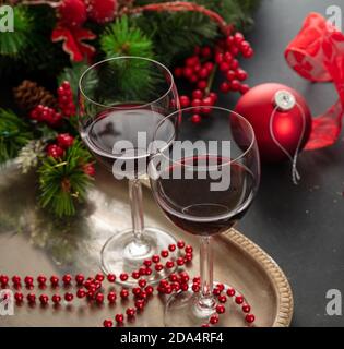 Weihnachtlicher Rotwein. Zwei Weingläser in einem silbernen Tablett bereit zum Servieren, festliche Weihnachtsschmuck Dekoration auf dem Tisch, Nahaufnahme. Winterurlaub Paket Stockfoto