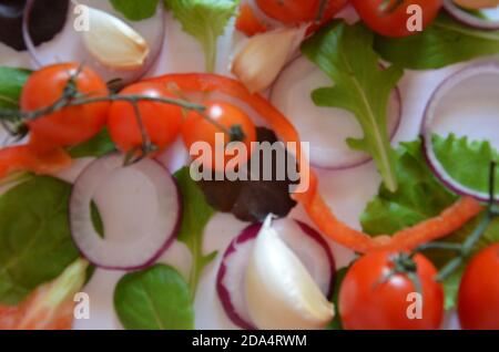 Bunte Salat Zutaten Muster aus Tomaten, Ruccola, lila Zwiebelringe, rote Paprika, Chili, Knoblauch, Gurkenscheiben und Basilikum auf weiß Stockfoto