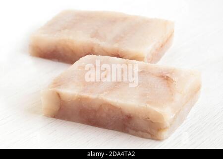 Zwei schnell gefrorene Fischfiletblöcke isoliert auf Weiß. Stockfoto