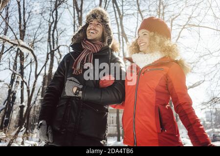 Pärchen, die im Winter einen Spaziergang durch den Wald machen Stockfoto