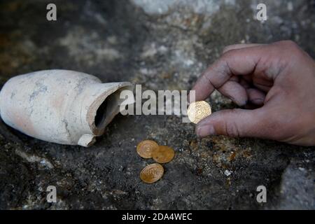 Jerusalem. November 2020. Ein Archäologe zeigt eine Goldmünze, die am 9. November 2020 an einer Ausgrabungsstätte in der Altstadt von Jerusalem ausgegraben wurde. Israelische Archäologen haben in Jerusalem einen 1,000 Jahre alten Töpferjuglet mit vier Goldmünzen ausgegraben, sagte die Israel Antiquities Authority (IAA) am Montag. Kredit: Gil Cohen Magen/Xinhua/Alamy Live Nachrichten Stockfoto