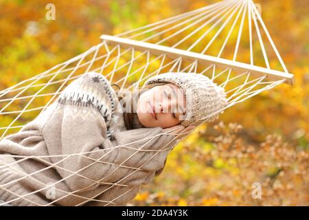 Schönheit Frau schlafen bequem auf Seil Hängematte in einem Wald In der Herbstsaison Stockfoto