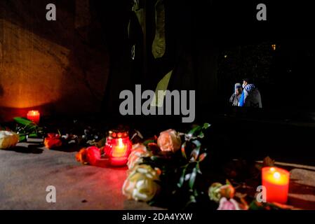 Deutschland, Berlin, 09. November 2020: Zwei Protestierende sind hinter Blumen und Kerzen zu sehen, wenn Menschen bei einer Kundgebung am Deportationsdenkmal Levetzowstraße in Berlin-Moabit am 82. Jahrestag der antisemitischen Novemberpogrome vom 9. November 1938, auch bekannt als Kristallnacht oder Nacht der zerbrochenen Brille, an Opfer des Nazi-Regimes erinnern. Die Angriffe der Nazis waren der Auftakt zu offener Gewalt gegen Juden. Rund 400 Juden wurden in der Nacht ermordet, Hunderte weitere wurden verhaftet, deportiert und gefoltert. Mehr als 1,400 Synagogen sowie tausende Geschäfte, Stockfoto