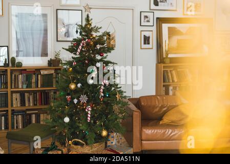 Weihnachtsfest. Wunderschön eingerichtetes Haus mit einem Weihnachtsbaum und Geschenk darunter. Stockfoto